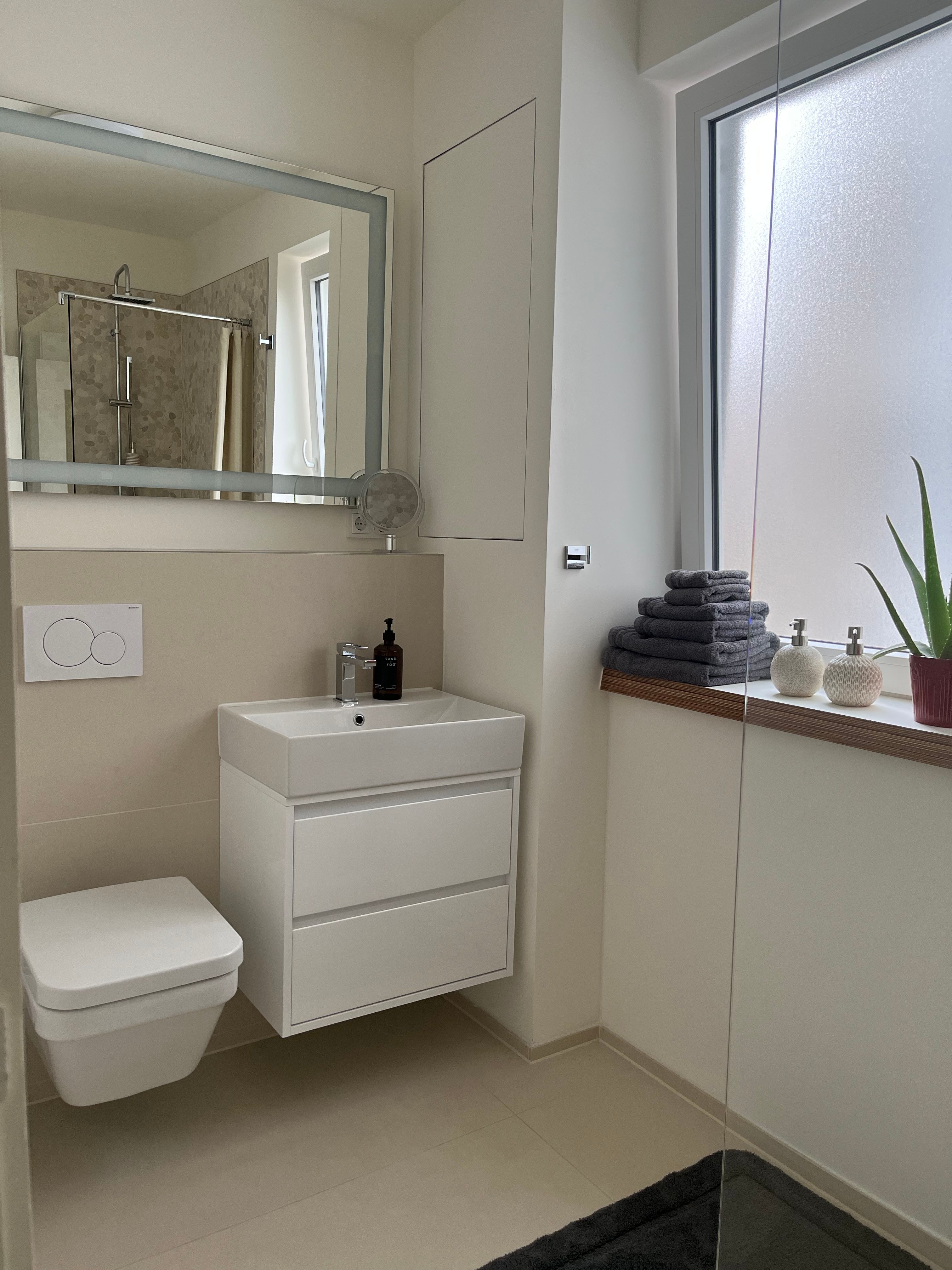 Bad mit begehbarer Dusche, Regenkopf und beheizbarem Handtuchhalter.