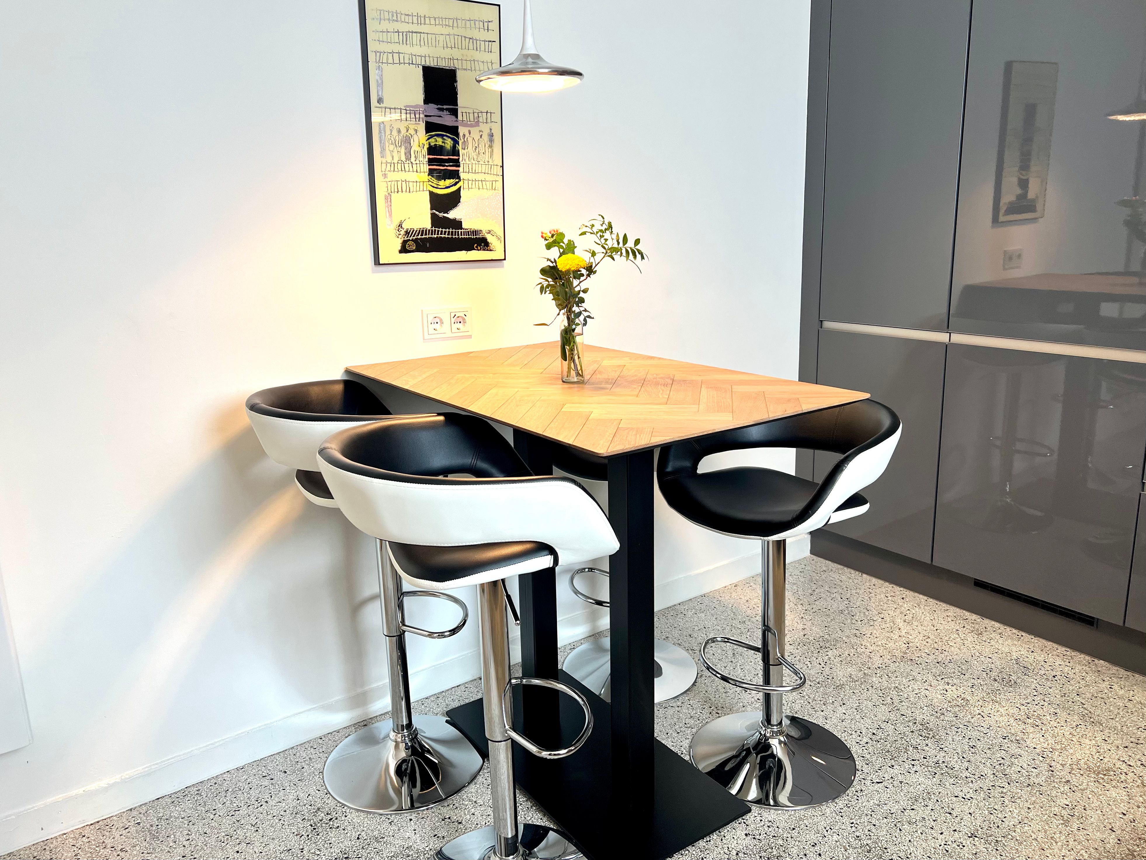 High table in the kitchen with a bar stool, sockets and a USB port in the wall.